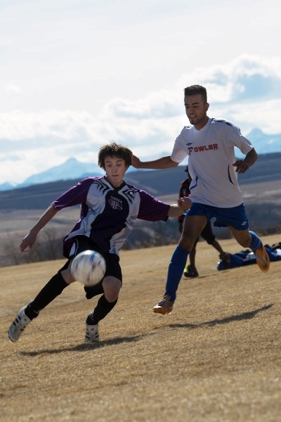 St. Timothy Thunder&#8217;s Brett Berndt works the ball against an attacking James Fowler defender in Calgary Senior High School Athletic Association boys soccer play April