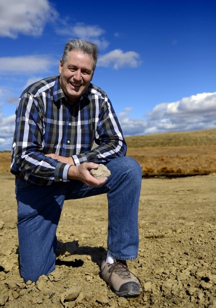 Bruce Pettigrew holds a handful of gravel from the future sight of Cochrane&#8217;s newest K-8 elementary school May 2. The new school will be built in the community of