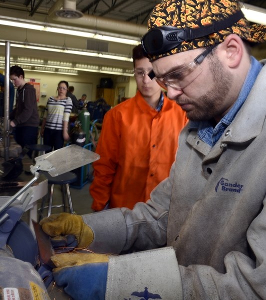 Keith Routhier demonstrates some grinding techniques used by his students at St. Timothy High School.