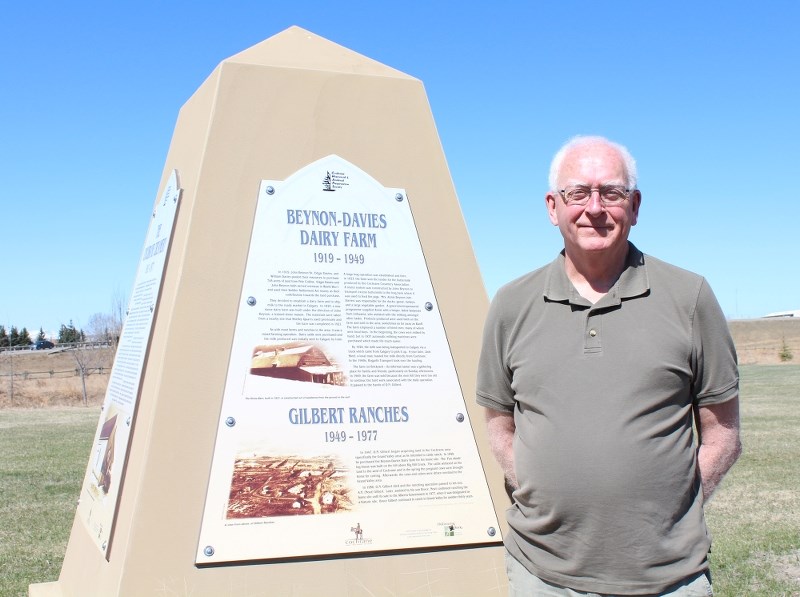 Gordon Davies, president of the Cochrane Historical and Archival Preservation Society, stands alongside the cairn dedicated to the five businesses that called the Cochrane