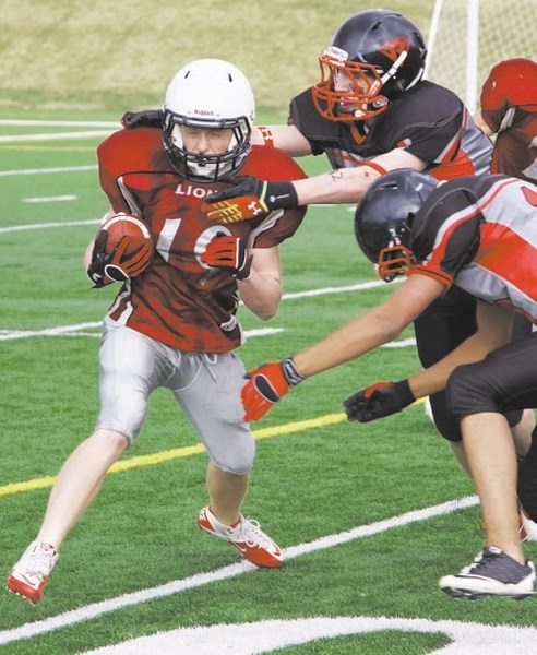 Cochrane Lions kick-returner Bailey Gordon braces for impact in Calgary and Area Midget Football Association playoff play May 15 against the Northern Raiders of Airdrie at