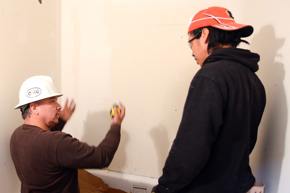 Trainer Mike Brass and Steven Baptist work on a project June 10.