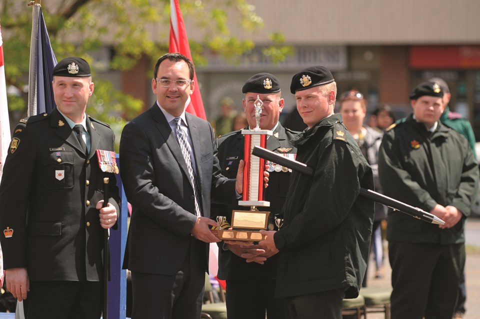 From left, Warrant Officer Troy MacGillivray, Wild Rose MP Blake Richards and Lieutenant-Colonel Ross H. Wickware pose with Warrant Officer Liam Murphy as he receives an