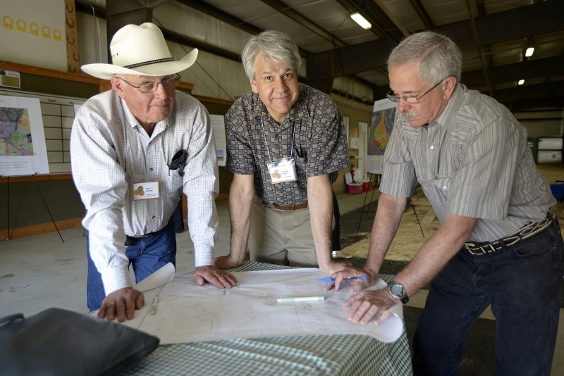 From left, Brian Birchall, Roberto Binda and Gord Lackey look at some maps of the Ag Society grounds during the Cochrane District Agricultural Society open house on July 4.