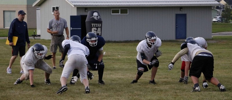 Bow Valley Bobcats head coach Scott Allard (far left) and position coach Harv Davies monitor the line in Aug. 29 training camp drills.