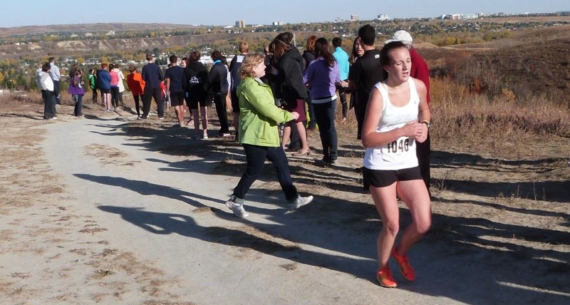 St. Timothy High School Thunder cross-country runner Jessica Brolsma reaches the top of Canada Olympic Park after running four kilometres from the bottom at the Calgary