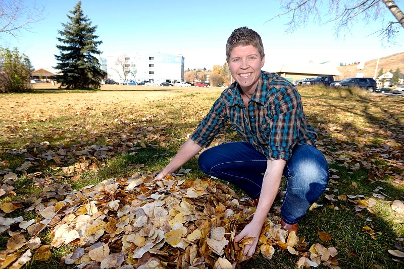 Sharon Howland, waste and recycling manager for the town, collects a pile of leaves Oct. 22 in Cochrane.