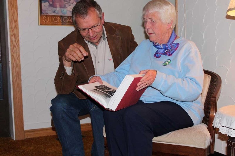Governor General&#8217;s Caring Canadian Award recipient Karen Nordgaard shares her family&#8217;s history book with Macleod MP Ted Menzies, who congratulated her at a