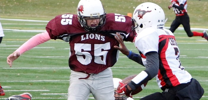 Cochrane Lions defender Luke Kruger goes right to the ball in Calgary Bantam Football Association seeding-round playoff play against the Calgary Stampeders Oct. 19 at