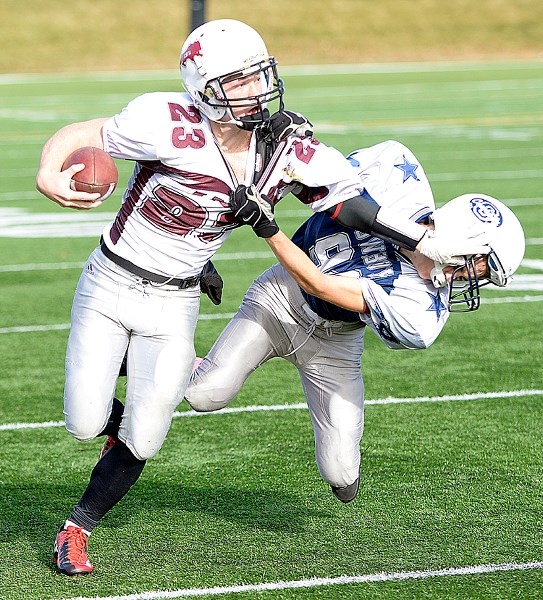 Cochrane Lions quarterback Tae Gordon (left) shows a Calgary Cowboys Grey would-be tackler where the ground is. But the Calgary team prevailed, bouncing the Lions from