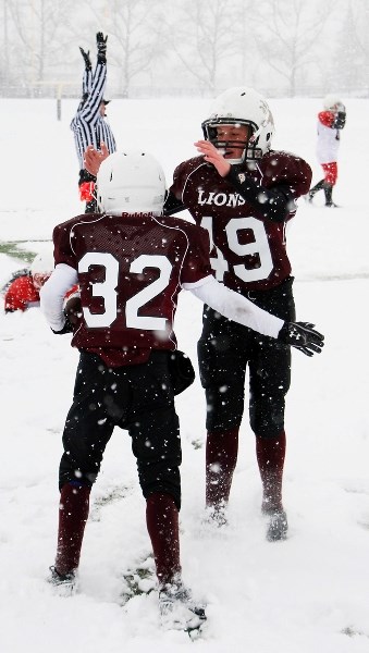 Koby Brander congratulates Cochrane Lions teammate Dawson Gladue after Gladue scored a touchdown against the Calgary Broncos in Calgary Peewee Football Association Division 3 
