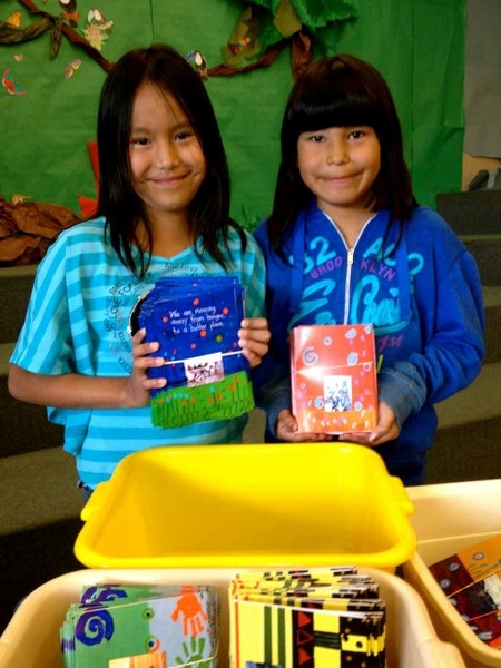 Rain Goodstoney (left) and Serenity Fox show off a few of the greeting cards they worked on as part of Warrior Paint: Painting to Fight Hunger. Proceeds from the project go