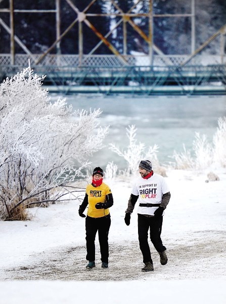 Richard and Glenda Zamzow walk with the Marathon Quest 250 Run/Walk on Dec. 31 along the Bow River, near River Avenue in Cochrane.