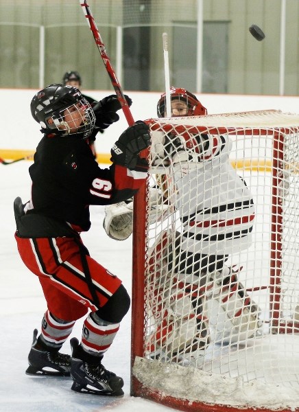 Bow Valley Timberwolves forward Connor Bouchard watches the puck sail over Wheatland Braves goalie Kenny Holt-Stewart in provincial peewee AA playdown play Jan. 23 in