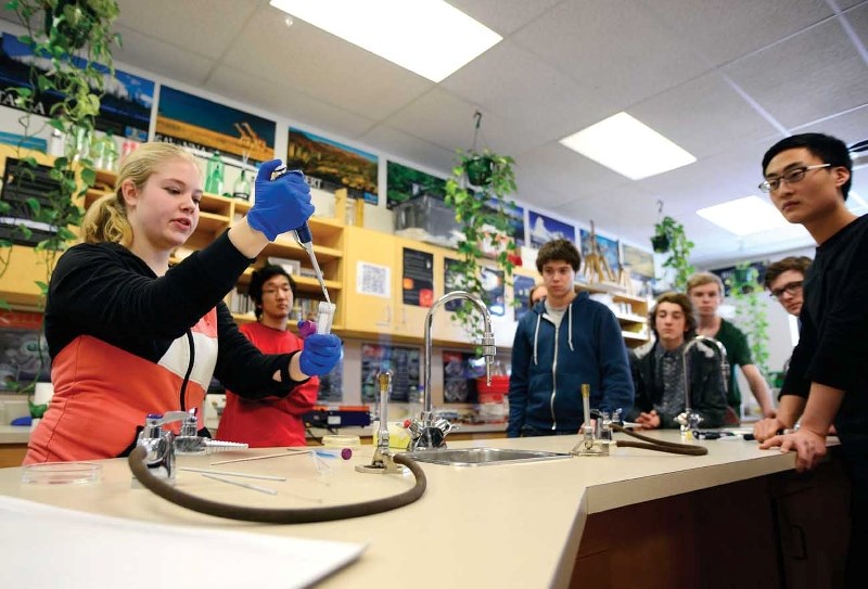 Lisa Oberding, an undergraduate from the University of Calgary, shows students from Cochrane High School the basics of synthetic biology Feb. 6.