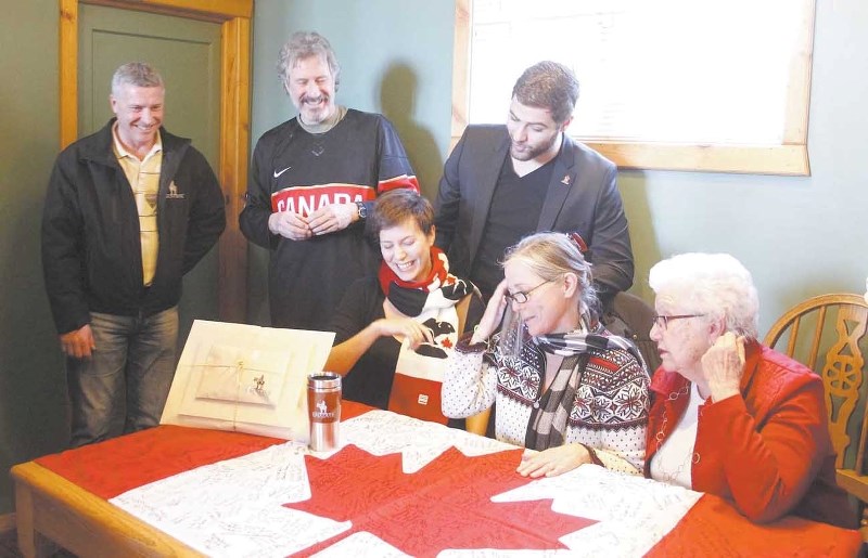 From left: Cochrane Mayor Ivan Brooker, Bruce Walker, Asia Walker, Lochlan Walker, Karen Bolger and Jean Bolger take one last look at the Canadian flag Feb. 9 signed by 500