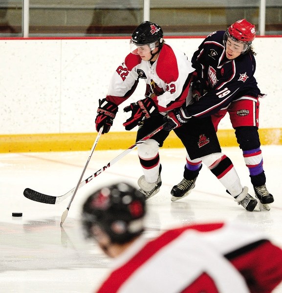 Cochrane Generals captain Tyson Soloski (right) battles Three Hills Thrashers&#8217; Russell Olson for the puck in Heritage League play Feb. 7 in Cochrane. The Generals