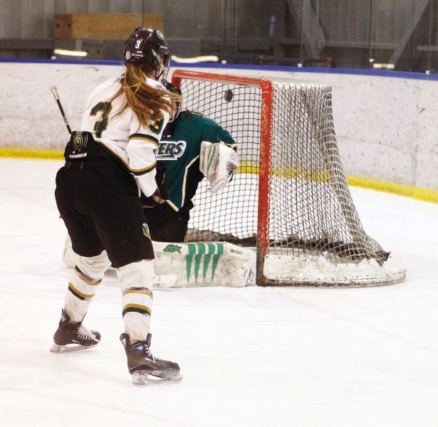 Highwood Raiders forward Nicolette Seper roofs a backhand over Calgary Flyers goalie Alicia Anderson in Alberta Major Midget Female Hockey League playoff action Feb. 23 at