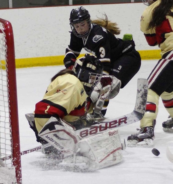 Highwood Raiders forward Nicolette Seper tries to score on Red Deer Chiefs goalie Nisa Bartlett in Alberta Major Midget Female Hockey League South Division final play March 8 