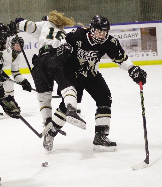 Rocky Mountain Raiders forward Taylor Sawka takes a stiff hip-check from Calgary Outlaws&#8217; Jessica Kondas in Alberta Major Bantam Female Hockey League playoff play March 