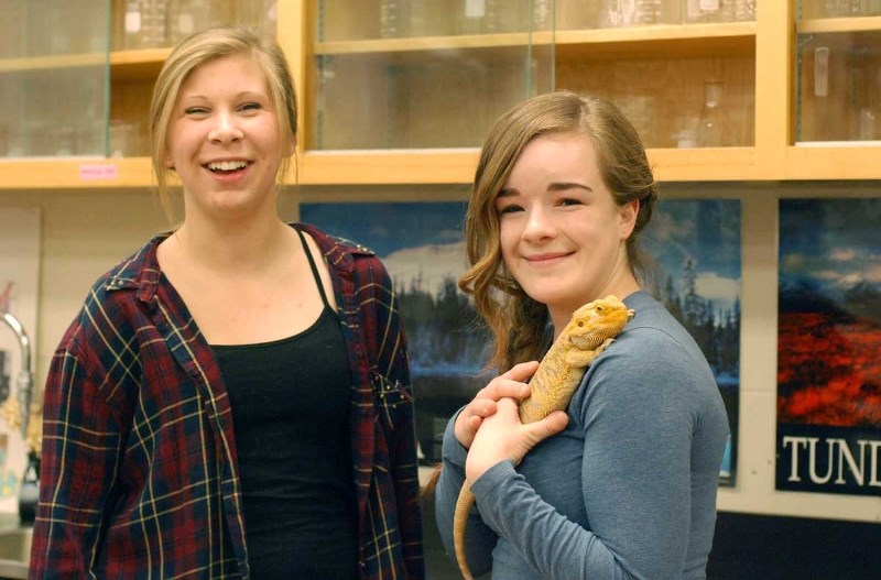 Charlotte Harrison, left, and Megan Puzey, with Buddy the bearded dragon, presented their teaching project, TAVI, to a group of medical professionals, which was met with