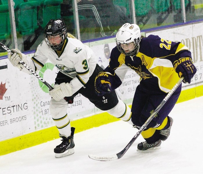 Rocky Mountain Raiders forward Kara Kondrat chases the puck into the corner ahead of St. Albert Raiders&#8217; Hayley Basterash in Alberta Major Bantam Female Hockey final