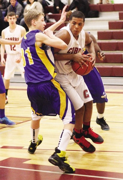 Cochrane High School Cobras junior-varsity centre Justin Sambu pounds the ball inside against the Bert Church Chargers at the Zone tournament in March. Sambu is one of 12