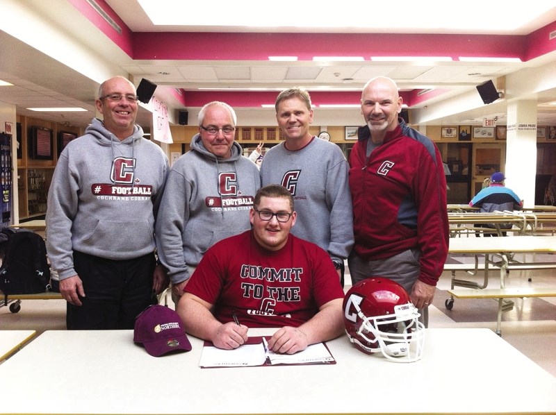 Cochrane High School Cobras football coaches (from left) Bruce O&#8217;Neil, Jim Forrest, Rob McNab and Ken Polson are present as player Dale Cummings signs on to play for
