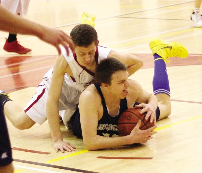 Cobras shooting guard/wing Jake Nielson (left, battling Bow Valley Bobcats&#8217; Joel Yepiz for the ball in March league play) is playing for Alberta&#8217;s Under-16