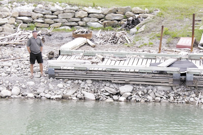 Graham Mehain, an avid boater of Ghost Lake for 15 years, stands beside his boat dock — which would normally be put in the water by July 1, but will likely not be able to be
