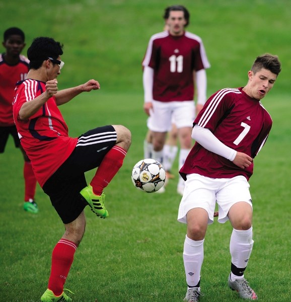 Cochrane High School Cobras&#8217; Nick Fisher (right) keeps an eye on the ball in Alberta Schools&#8217; Athletic Association South Central Zone boy&#8217;s soccer play June 