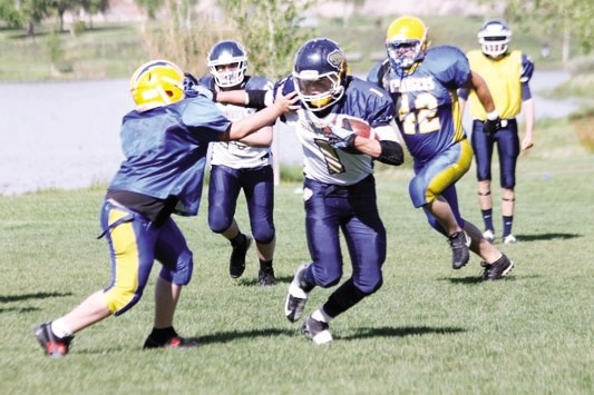 Bow Valley Bobcats running back Scott Haigh works for yards against Bert Church Chargers at June 9 high school exhibition football jamboree in Airdrie.