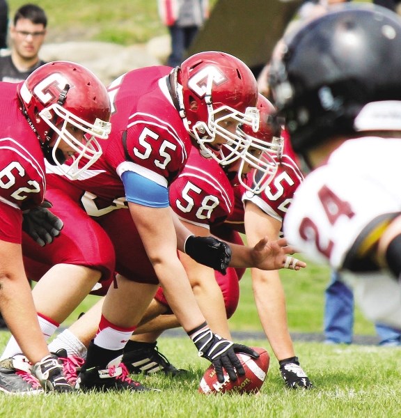 Cochrane High School Cobras centre Brock Wiebe (55) fires off the ball and into the line of scrimmage against Foothills Composite Falcons at Holy Trinity Academy&#8217;s June 