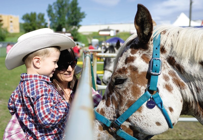 Dexter Byrnes and his mother Janelle pet Mr. Bean at last year&#8217;s SummerFest, when close to 1,000 locals and visitors came through the gates of Cochrane&#8217;s annual