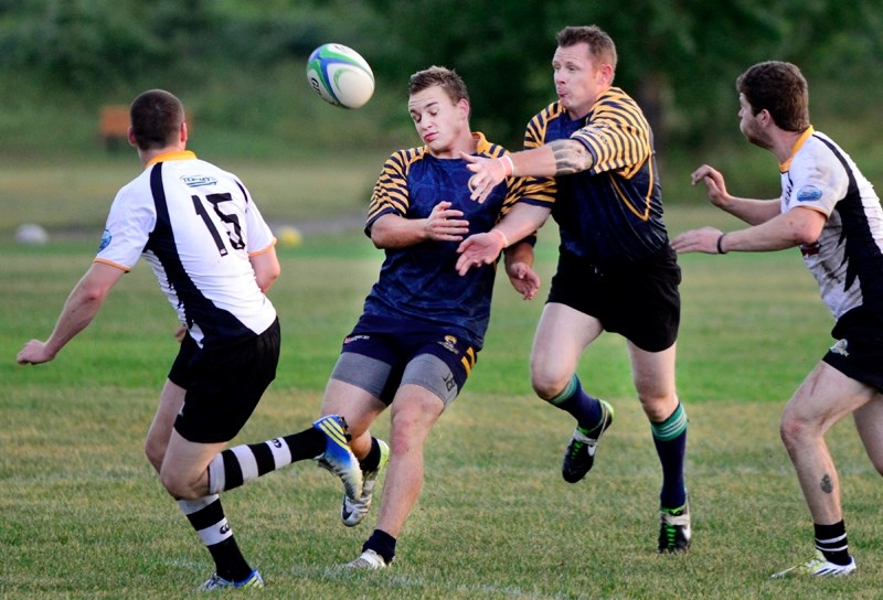 Cochrane Grizzlies James Patterson (centre, left) and Kevin Canning chase a loose ball in Calgary Rugby Union Div. 3 men&#8217;s play against Banff on Aug. 15 in Cochrane.