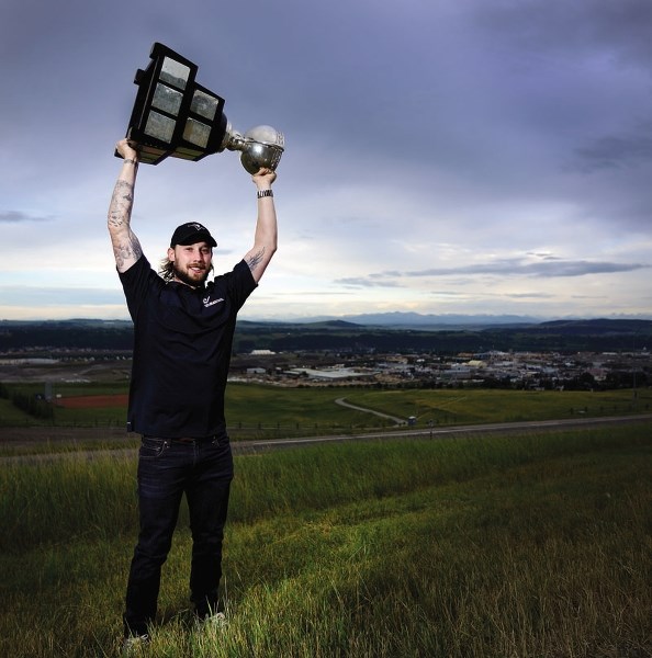 Dowling lifts the Calder Cup over his head with Cochrane in the Background.