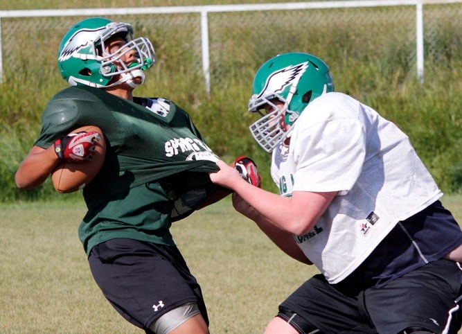 Trey Adams tries to escape the clutches of Callum McCulloch-Graham at Springbank Community High School Phoenix football training camp Aug. 25 in Springbank. The Phoenix have