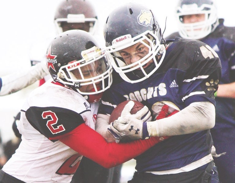Bow Valley High School Bobcats running back Marshall van Iderstine (right) brings a load in Rocky View Sports Association football play against Chestermere Cowboys Sept. 12