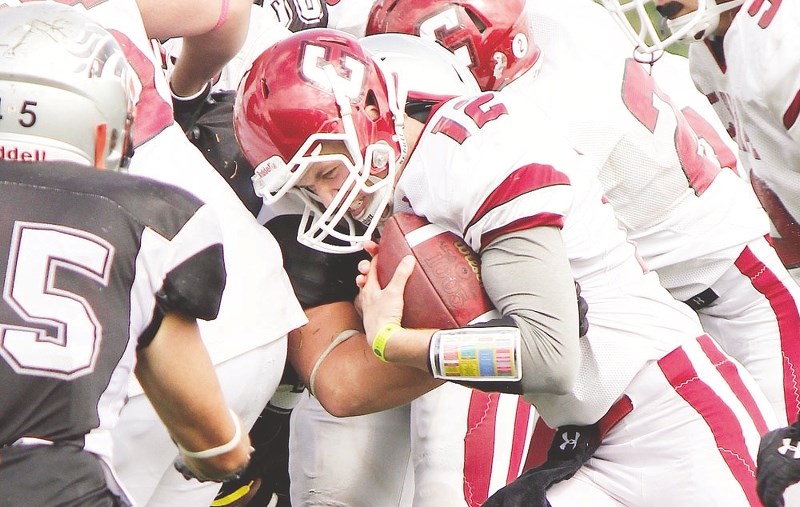 Cochrane High School Cobras senior quarterback Cody Stevens slams into the line of scrimmage on a third-and-short run against George McDougall High School Mustangs Sept. 13