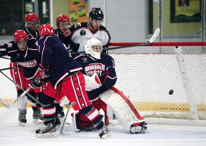 Cochrane Generals netminder Garrett Iverson has one sneak by him as Blackfalds Wranglers forward Trent Hermary crowds the side of the net in Heritage Junior Hockey League