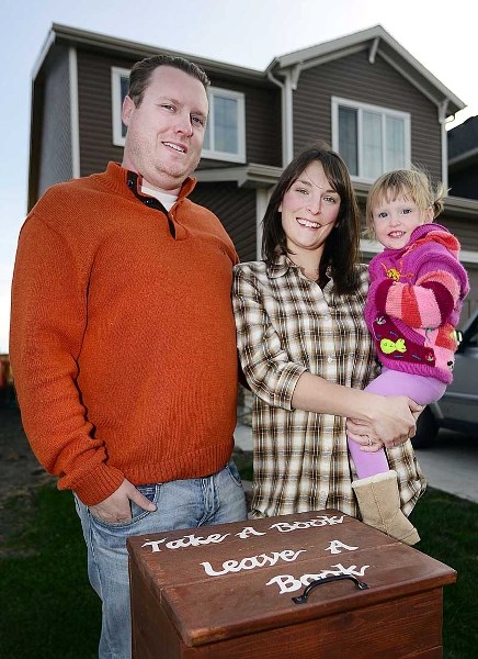 Sean Higgins, Ashley Ernest and their daughter Kierra Higgins, beside their Little Free Library Oct. 14.