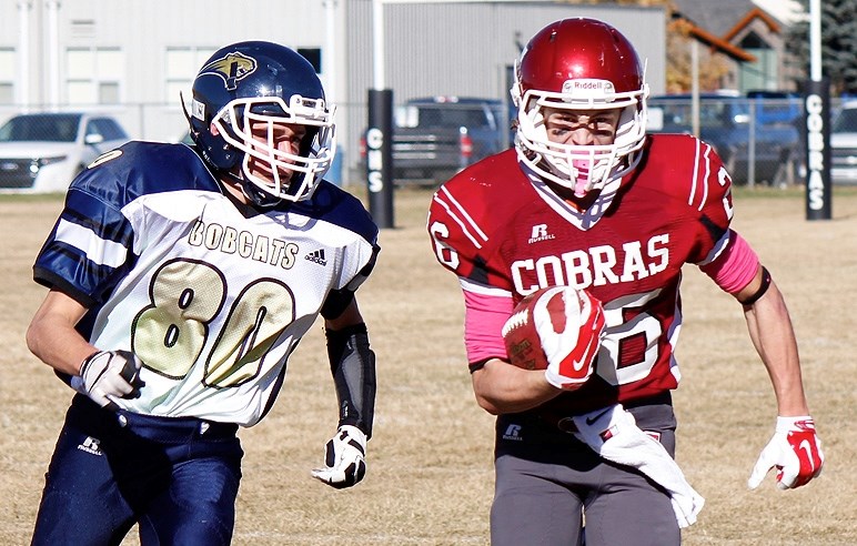 Cochrane Cobras receiver Erik Nusl charges for the front corner of the endzone, chased by Bow Valley Bobcats defensive back Michael Audia in Rocky View Sports Association