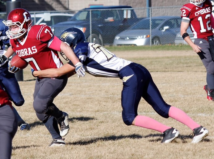 Bow Valley Bobcats defender Jaydon Kibzey latches on to Cochrane Cobras running back Mac Chaisson in Rocky View Sports Association high school playoff football play Oct. 18.