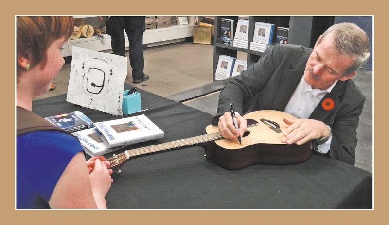 Retired Canadian astronaut Chris Hadfield delighted Cochrane student Emmeline Maillet-Snell by signing her guitar amidst autographing copies of his latest book, You Are Here, 