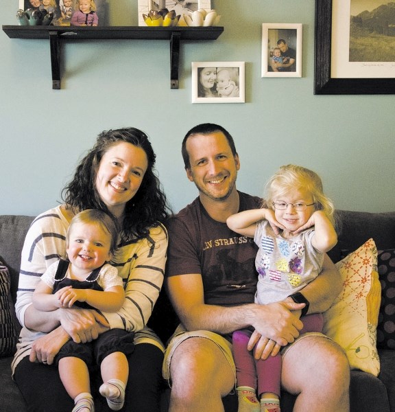 Laura and Trevor McDonald sit with daughters Freya (left) and Violet (right) in their Cochrane home. Violet is this year&#8217;s Children&#8217;s Hospital Foundation child