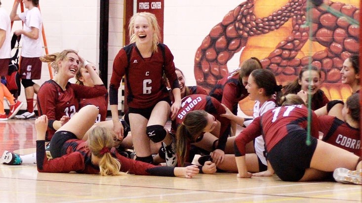 Cochrane Cobras celebrate in a heap on the gym floor after defeating Airdrie&#8217;s George McDougall Mustangs 3-1 (25-22, 23-25, 27-25, 25-16) in Rocky View Sports