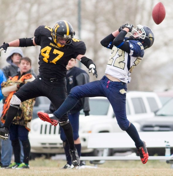 Bow Valley Bobcats receiver Nathan Hillier can&#8217;t squeeze the ball as Olds Spartans defender Ryland Couture disrupts the play in Alberta regional Tier 4 high school