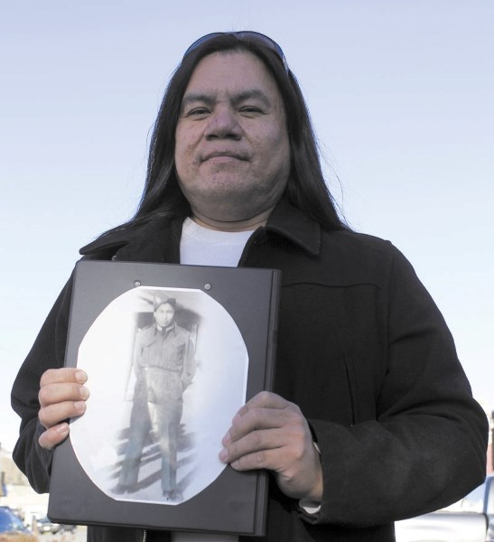 Stoney Nakoda First Nation resident Kenny Hunter holds a picture of his great uncle, Joe Poucette, who served as a rifleman in the Second World War. Poucette was killed in