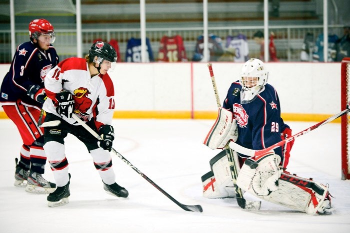 Cochrane Generals goalie Mackenzie Chalmers stops a nice backhand shot from Three Hills Thrashers&#8217; Patrick Fougere as defenceman Austin Keller backs up the play. Gens