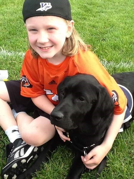 Redwood Meadows Dogs with Wings Assistance Dog Society volunteer puppy raiser Michelle Douglas&#8217;s son, Jake Moran, eight, poses with eight-month-old puppy Tiko at
